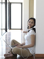 Image showing relaxed young woman at home working on laptop computer