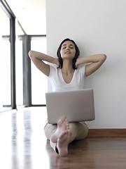 Image showing relaxed young woman at home working on laptop computer