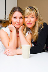 Image showing Two smiling girls in the kitchen