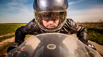 Image showing Biker racing on the road