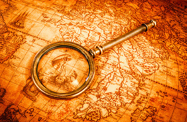 Image showing Vintage magnifying glass lies on an ancient world map