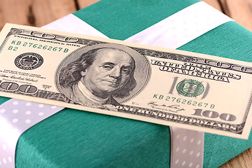 Image showing Holiday bonus.  american money on green gift box