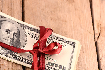 Image showing dollars wraped up with a red ribbon isolated on white background