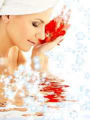 Image showing lady with red petals and snowflakes in water