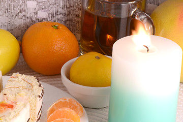 Image showing sweet cake on white plate with fruits and candle