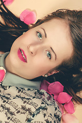 Image showing atractive brunette girl lying on beige background