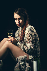 Image showing beautiful young brunette woman holding a bottle of white wine