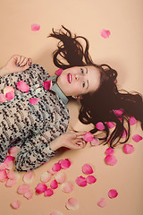 Image showing atractive brunette girl lying on beige background