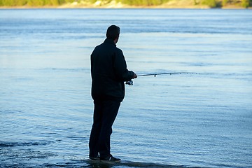 Image showing Modern clean fishing rod in hands