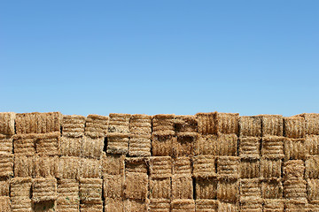 Image showing hay bales wall against blue sky