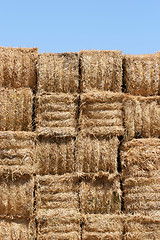 Image showing hay bales wall against blue sky