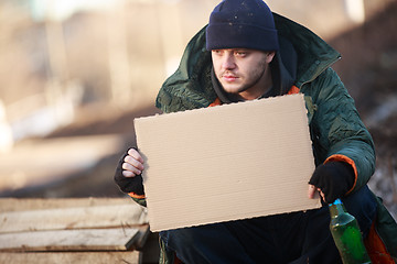 Image showing Homeless man holds blank cardboard for your text