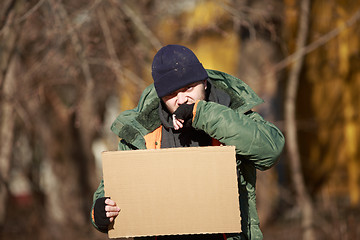 Image showing Homeless man holds blank cardboard for your own text