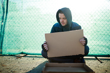 Image showing Homeless man holds blank cardboard for your text