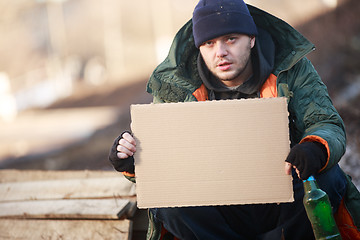 Image showing Homeless man holds blank cardboard for your text