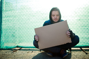 Image showing Homeless man holds blank cardboard for your text