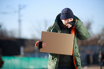 Image showing Homeless man holds blank cardboard for your own text