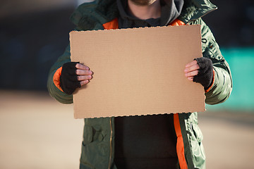 Image showing Homeless man holds blank cardboard for your own text