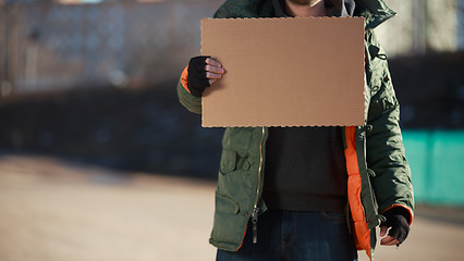 Image showing Homeless man holds blank cardboard for your own text