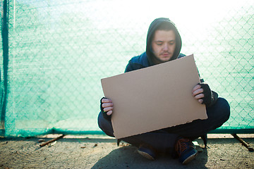 Image showing Homeless man holds blank cardboard for your text