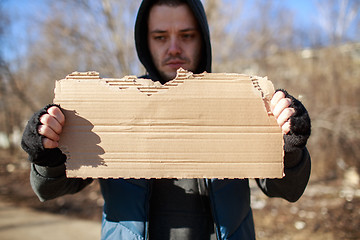 Image showing Homeless man holds blank cardboard for your text