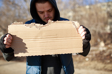 Image showing Homeless man holds blank cardboard for your text