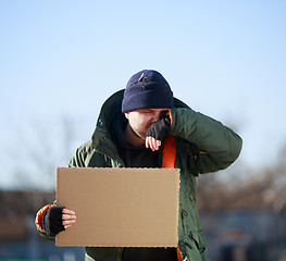 Image showing Homeless man holds blank cardboard for your own text