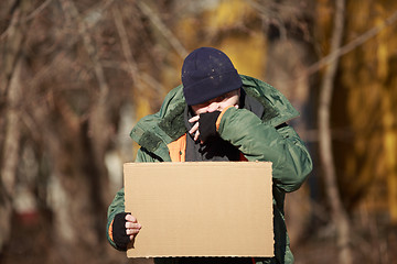 Image showing Homeless man holds blank cardboard for your own text