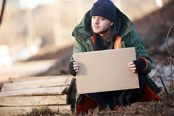 Image showing Homeless man holds blank cardboard for your text