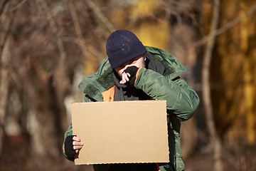 Image showing Homeless man holds blank cardboard for your own text