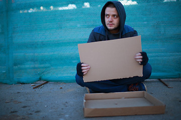 Image showing Homeless man holds blank cardboard for your text