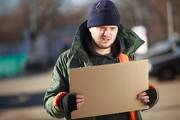 Image showing Homeless man holds blank cardboard for your own text