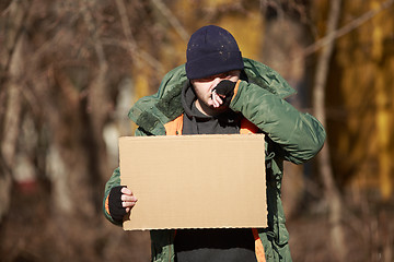 Image showing Homeless man holds blank cardboard for your own text