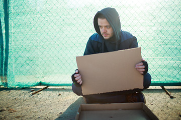 Image showing Homeless man holds blank cardboard for your text