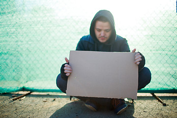 Image showing Homeless man holds blank cardboard for your text