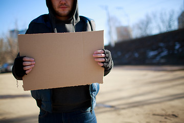 Image showing Homeless man holds blank cardboard for your own text