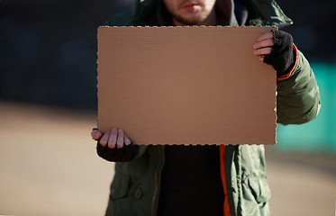 Image showing Homeless man holds blank cardboard for your own text