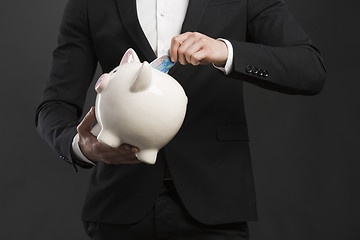 Image showing Holding a piggy bank