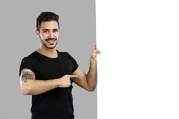 Image showing Latin man holding a blank billboard