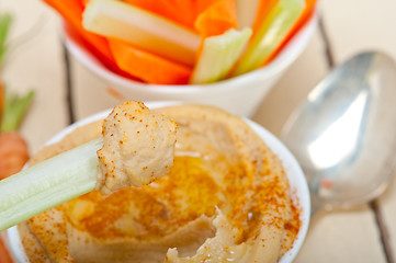 Image showing fresh hummus dip with raw carrot and celery 