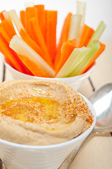 Image showing fresh hummus dip with raw carrot and celery 