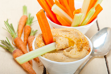 Image showing fresh hummus dip with raw carrot and celery 