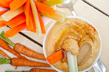 Image showing fresh hummus dip with raw carrot and celery 