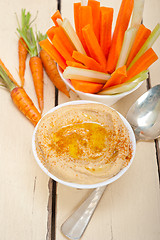 Image showing fresh hummus dip with raw carrot and celery 