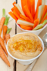 Image showing fresh hummus dip with raw carrot and celery 