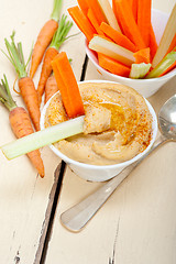 Image showing fresh hummus dip with raw carrot and celery 