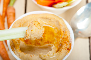 Image showing fresh hummus dip with raw carrot and celery 