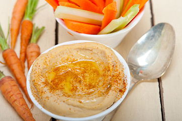 Image showing fresh hummus dip with raw carrot and celery 