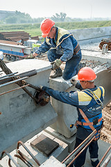 Image showing Two workers busy on bridge construction