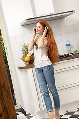 Image showing Happy Woman Talking Through Phone at the Kitchen